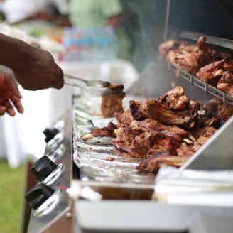 Meat being BBQed on a grill.