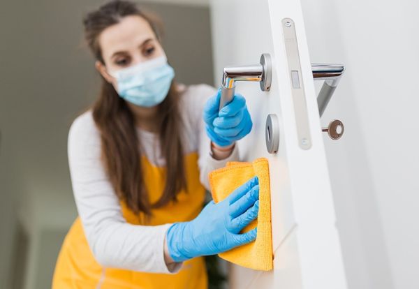 Woman wearing a mask cleaning a home in Palm Desert.